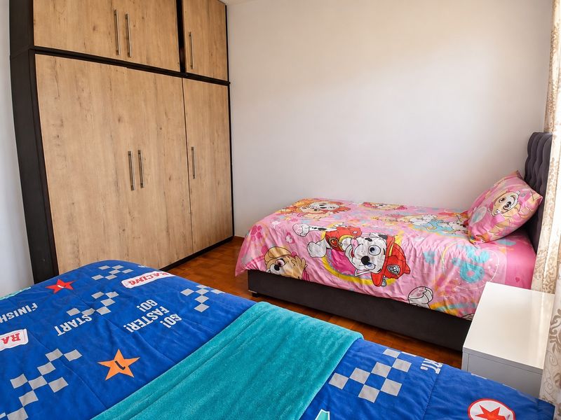 A bedroom featuring built-in wooden cupboards and parquet flooring, providing functional storage and a classic finish.
