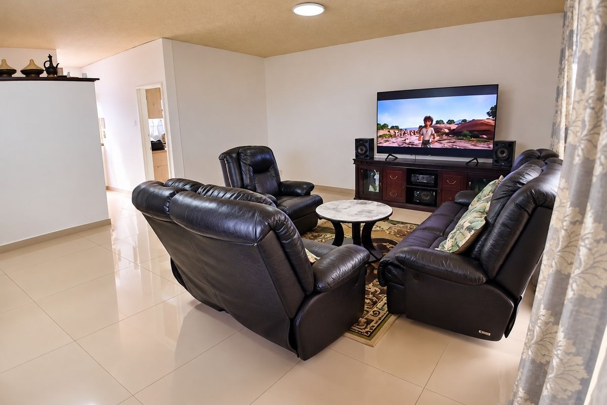 A spacious living room featuring polished tile flooring and a textured ceiling, providing a neutral foundation for comfortable family living.