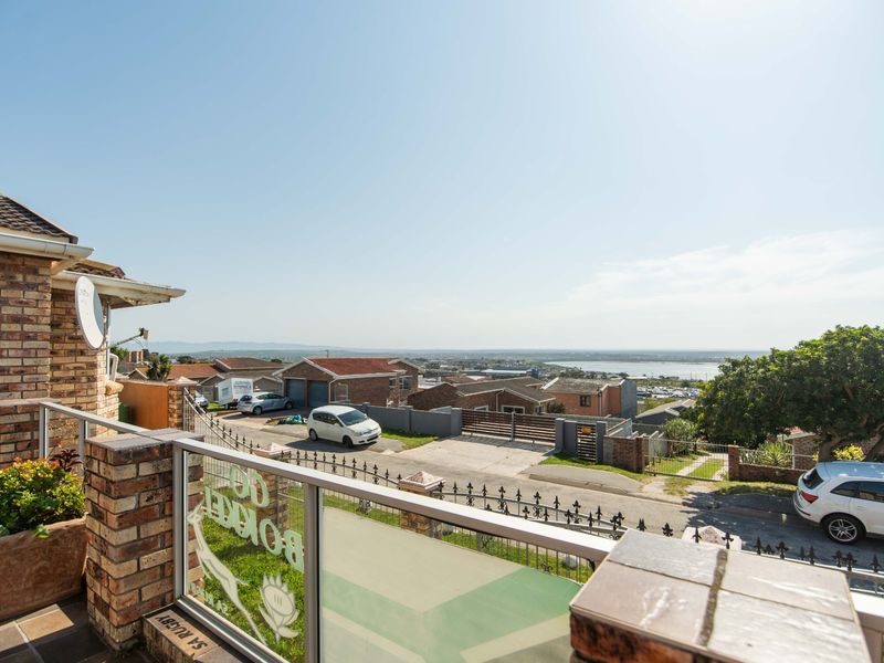 Elevated balcony with brick and glass balustrades, offering expansive views over the surrounding neighbourhood and distant landscape.