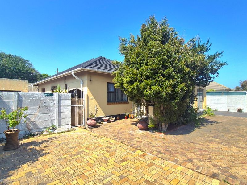 Front exterior view of the property featuring a brick paved driveway, precast boundary wall, and tiled roof structure.