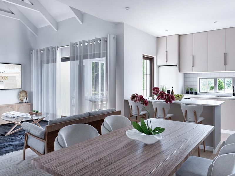 Modern open-plan living area featuring a vaulted ceiling, integrated kitchen with island, and seamless flow to the outdoor patio through sliding glass doors.