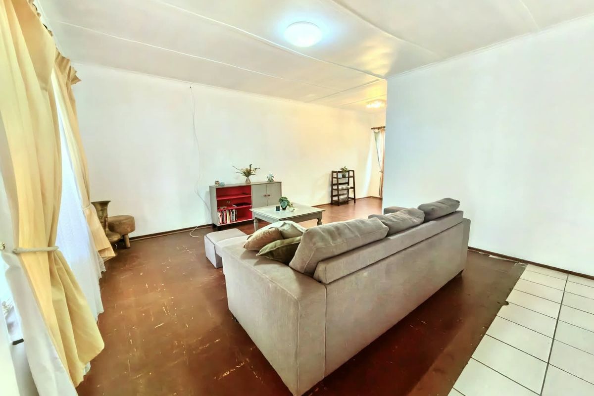 A living room area featuring tiled flooring and neutral wall finishes, offering a blank canvas for potential interior updates.