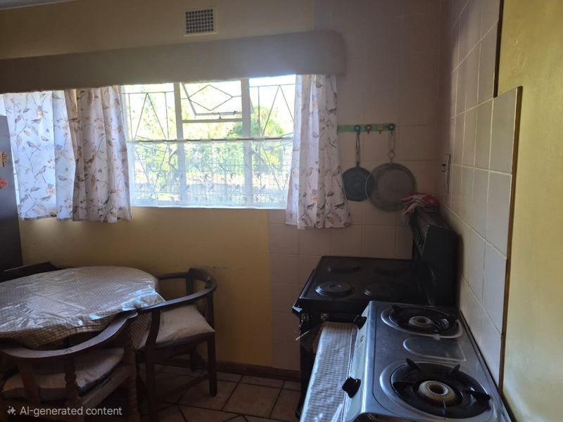 A dated kitchen area featuring tiled walls, tiled flooring, and security bars on the window, offering a functional space with potential for modernization.