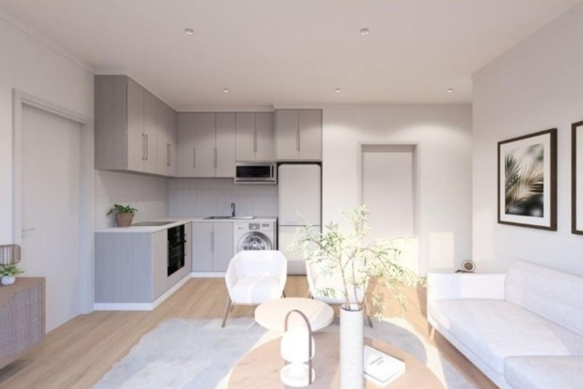 Modern open-plan living area featuring a compact, well-appointed kitchen with integrated appliances, light wood-look flooring, and recessed ceiling lighting.