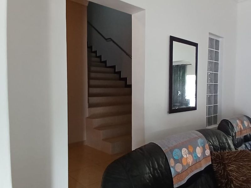A living area featuring an arched entryway and a staircase leading to the upper level, with glass block accents.