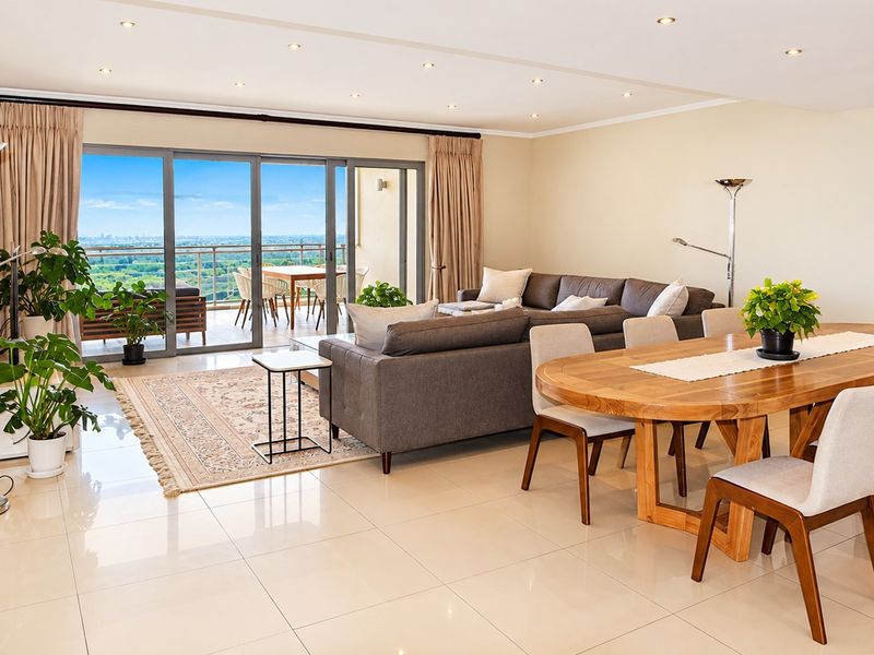 Spacious open-plan living and dining area featuring large sliding glass doors that open onto a balcony with expansive views.