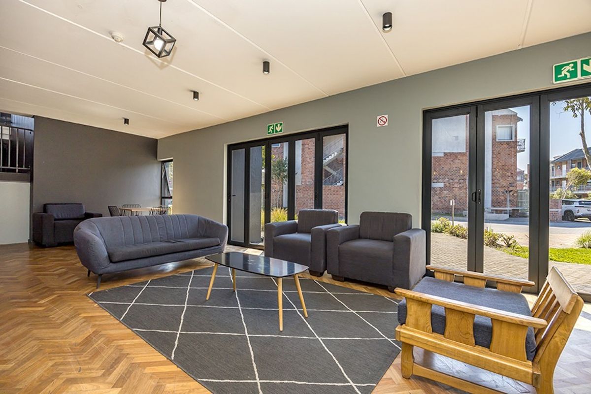 Spacious living area featuring elegant herringbone parquet flooring, modern recessed lighting, and large aluminium stacker doors providing seamless access to the exterior.