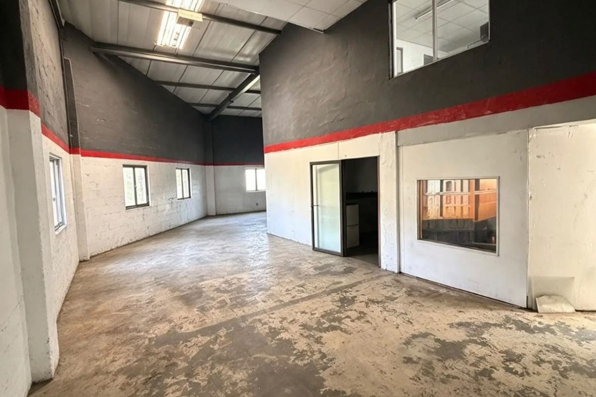 Spacious open-plan commercial unit featuring high ceilings, industrial concrete flooring, and internal office windows, offering a versatile blank canvas for business operations.