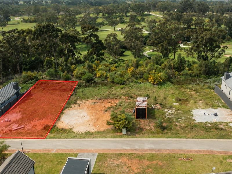Aerial view of a vacant residential plot situated in a golf estate, highlighting the undeveloped land and surrounding landscape.