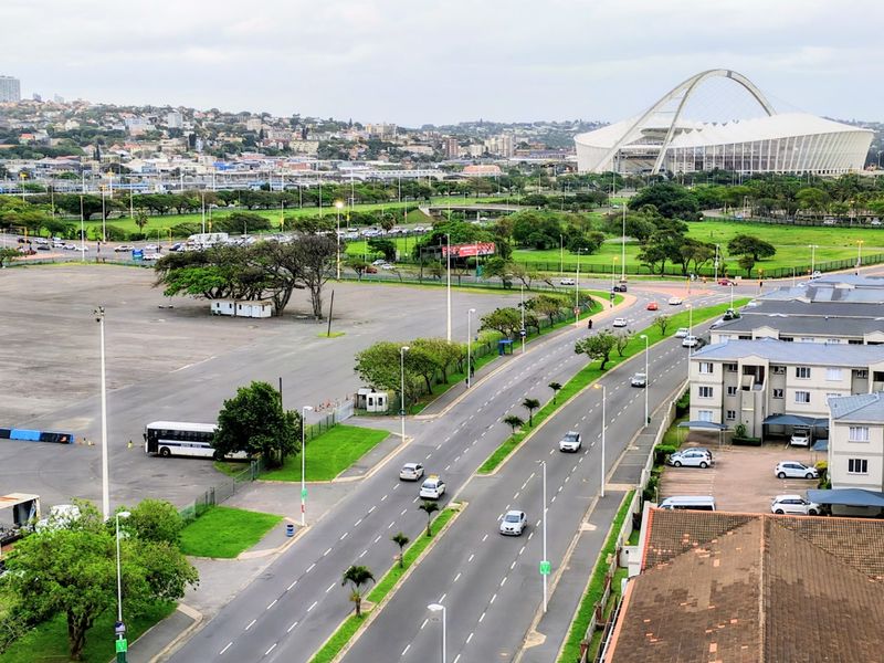Elevated view overlooking the surrounding urban area, featuring a prominent stadium and local road infrastructure.