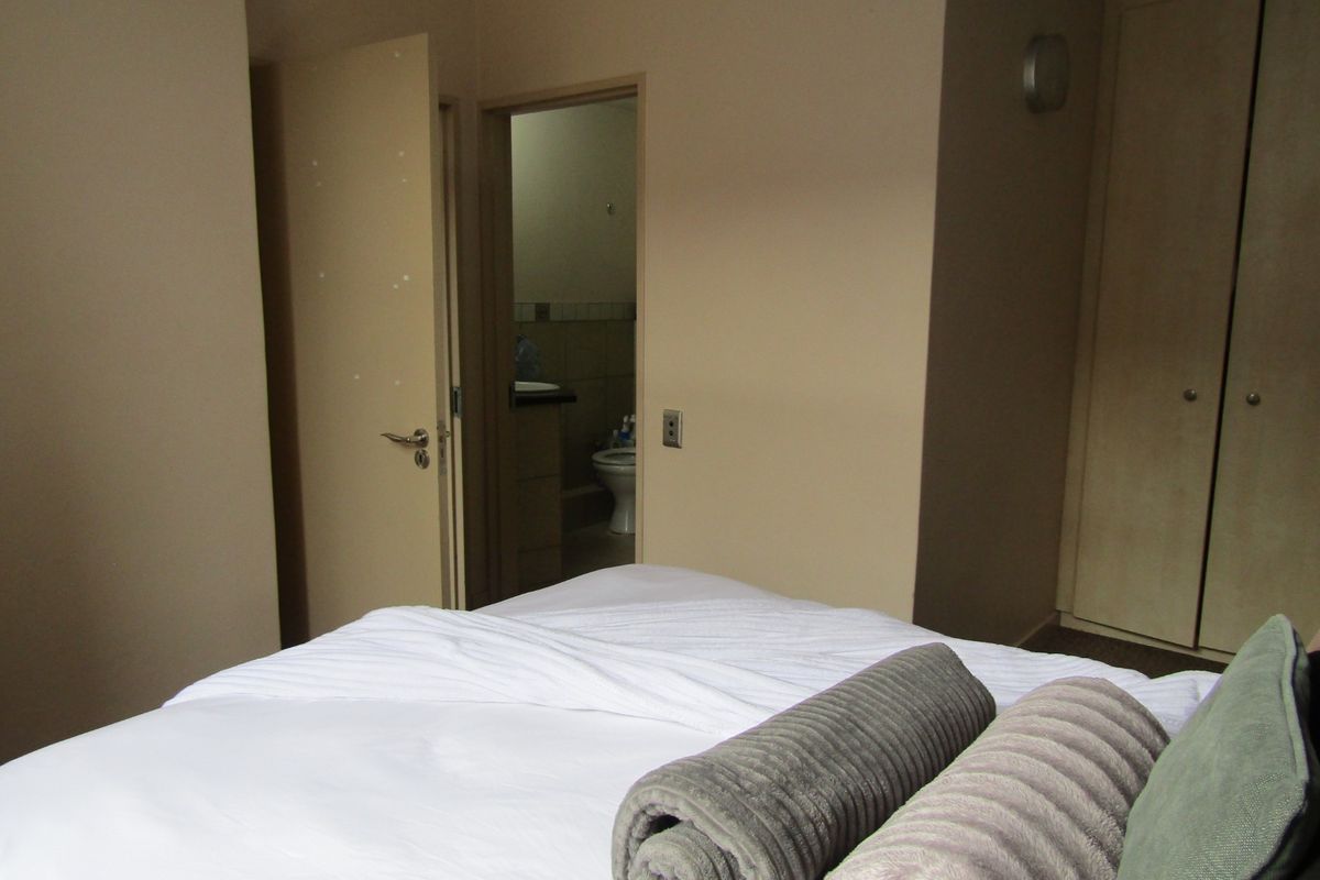 A bedroom featuring a built-in wardrobe and direct access to an en-suite bathroom.