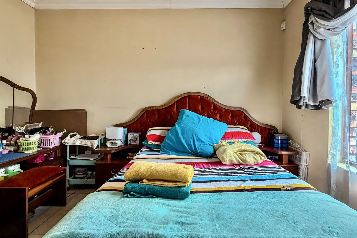 A bedroom featuring tiled flooring and coving, requiring cosmetic updates to the wall finishes to improve the overall aesthetic.