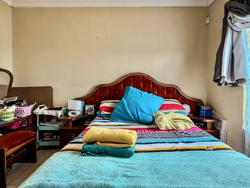 A bedroom featuring tiled flooring and coving, requiring cosmetic updates to the wall finishes to improve the overall aesthetic.