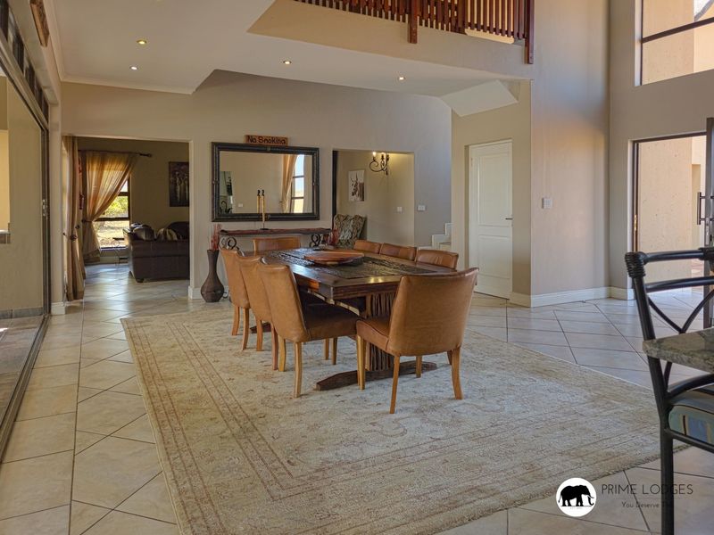 Spacious dining area featuring tiled flooring, recessed lighting, and an open-plan layout with a mezzanine level overlooking the space.