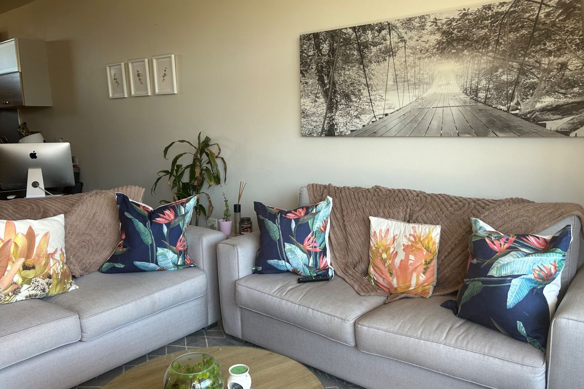 A comfortable living room space featuring neutral wall tones and ample room for seating arrangements.