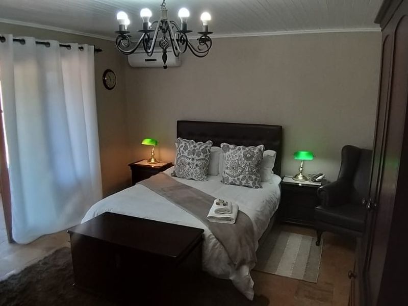 A bedroom featuring a split-system air conditioner, a chandelier, and sliding glass doors leading to an outdoor area.