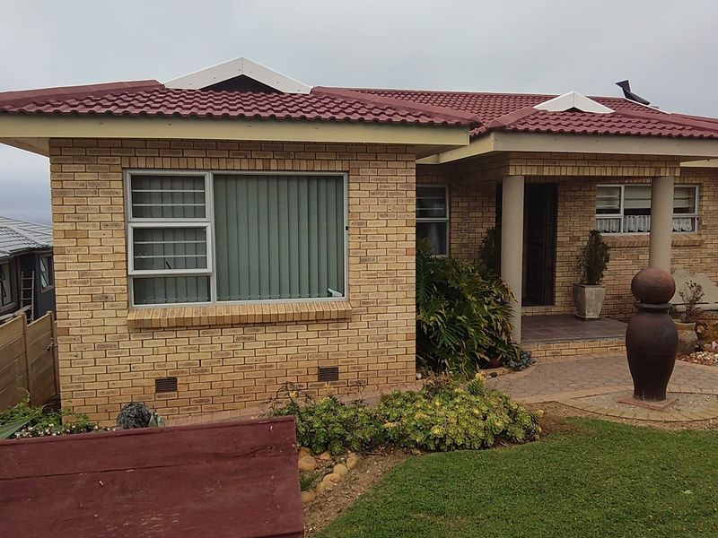 A well-maintained face brick house featuring a tiled roof, covered entrance with concrete columns, and a neat paved walkway leading to the front door.