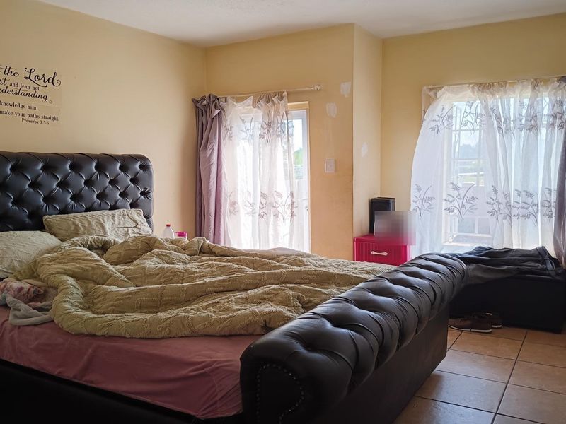 A bedroom featuring tiled flooring, a built-in wardrobe, and access to an outdoor area via a sliding glass door.