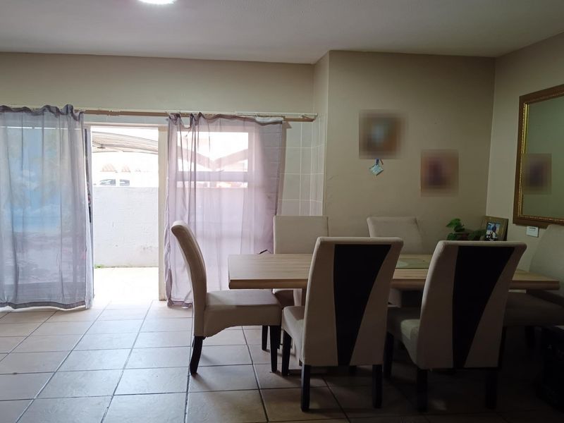 Dining area featuring tiled flooring and a sliding glass door providing access to the outdoor patio space.