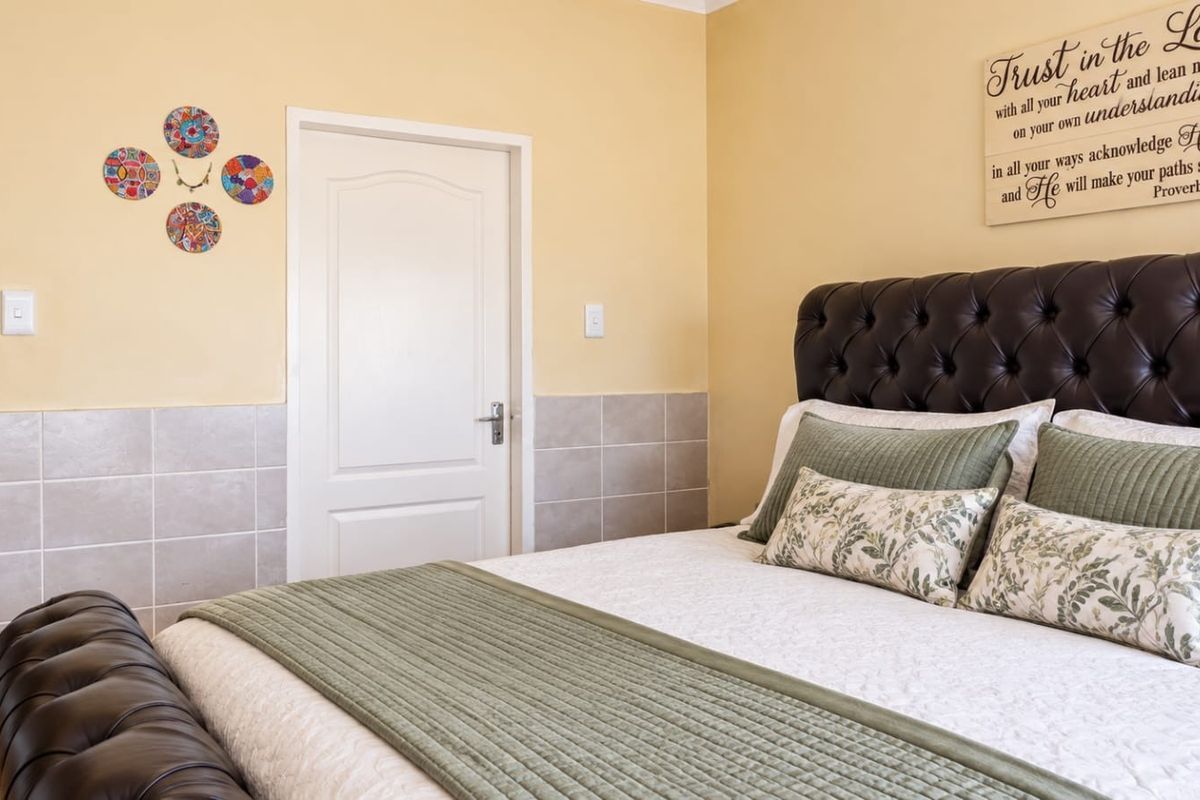 A bedroom featuring tiled wall wainscoting and neutral paint, providing a functional and well-maintained space.