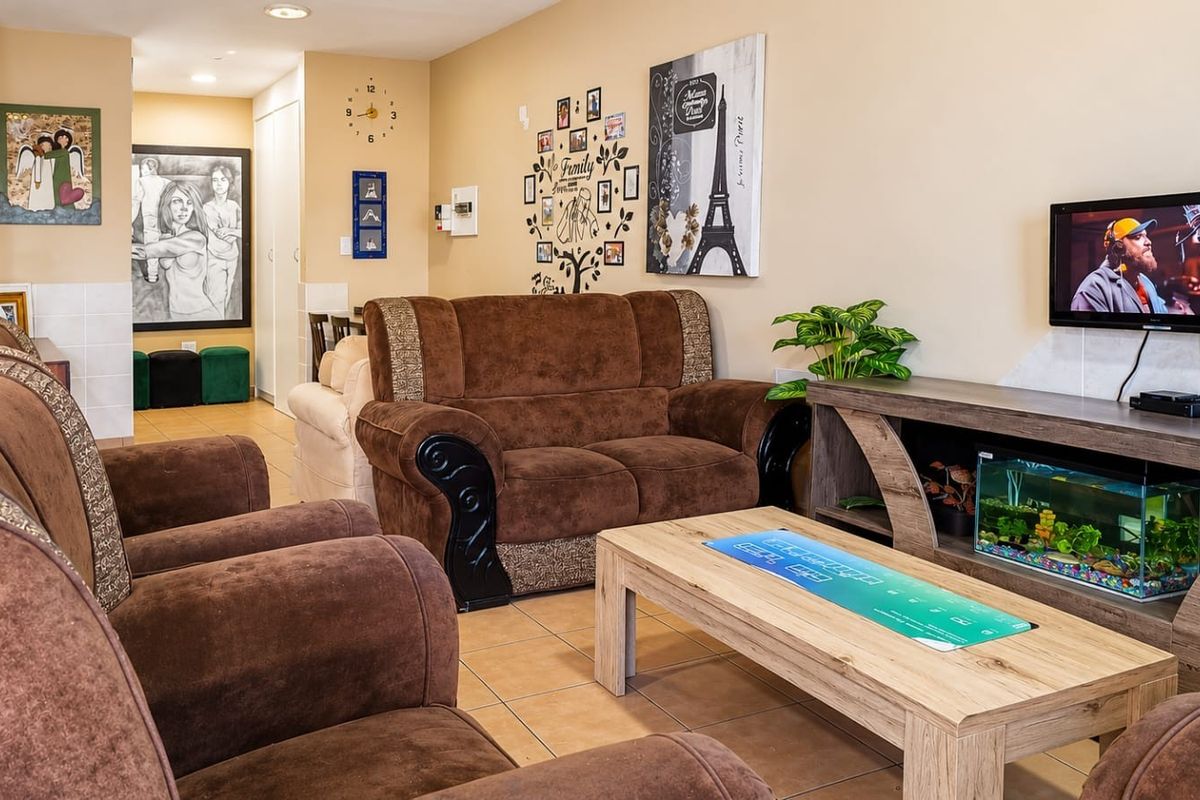 A comfortable living room featuring tiled flooring and recessed ceiling lighting, providing a functional and well-maintained space for relaxation.