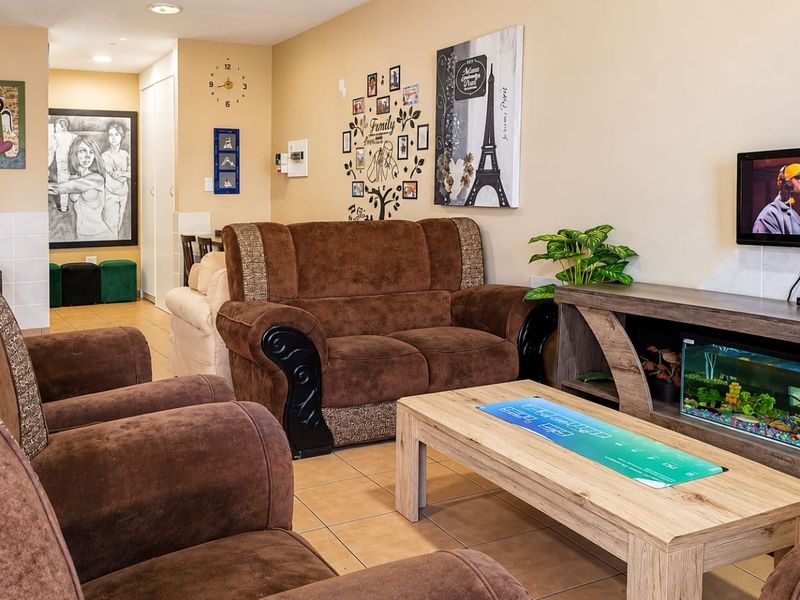 A comfortable living room featuring tiled flooring and recessed ceiling lighting, providing a functional and well-maintained space for relaxation.