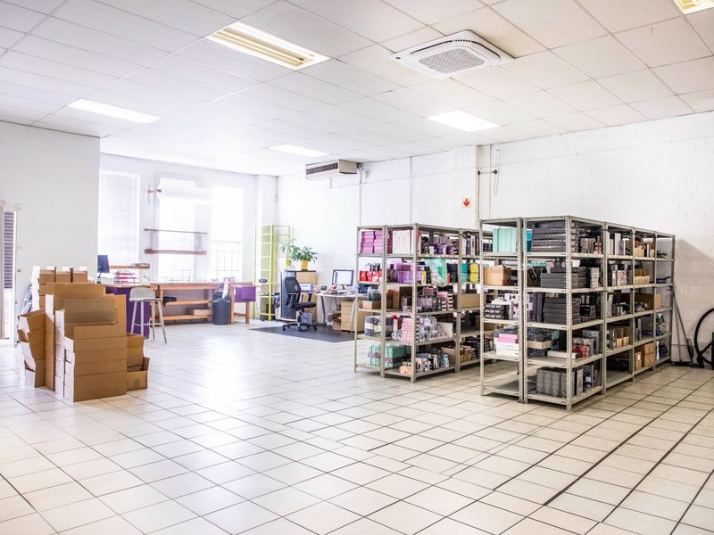 A spacious commercial utility or storage area featuring tiled flooring, suspended ceilings, and integrated air conditioning units.