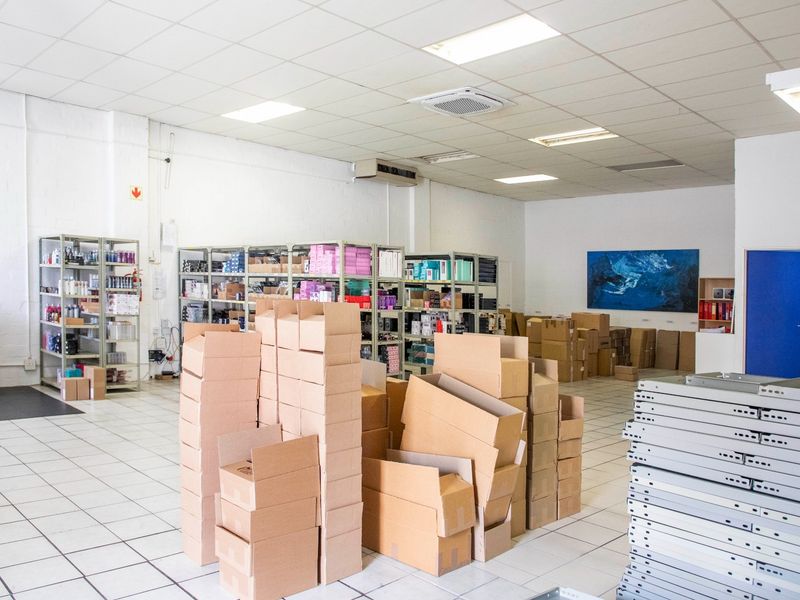 A spacious commercial utility or storage area featuring durable ceramic floor tiles, a suspended ceiling with recessed lighting, and integrated air conditioning.