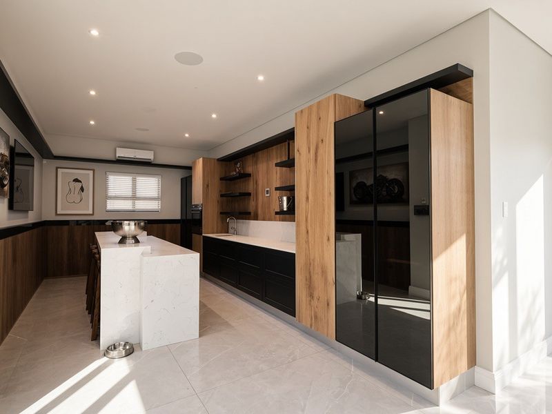 Modern, high-end kitchen featuring a stone-topped island, sleek wood and black cabinetry, integrated appliances, and recessed lighting in a bright, open-plan layout.
