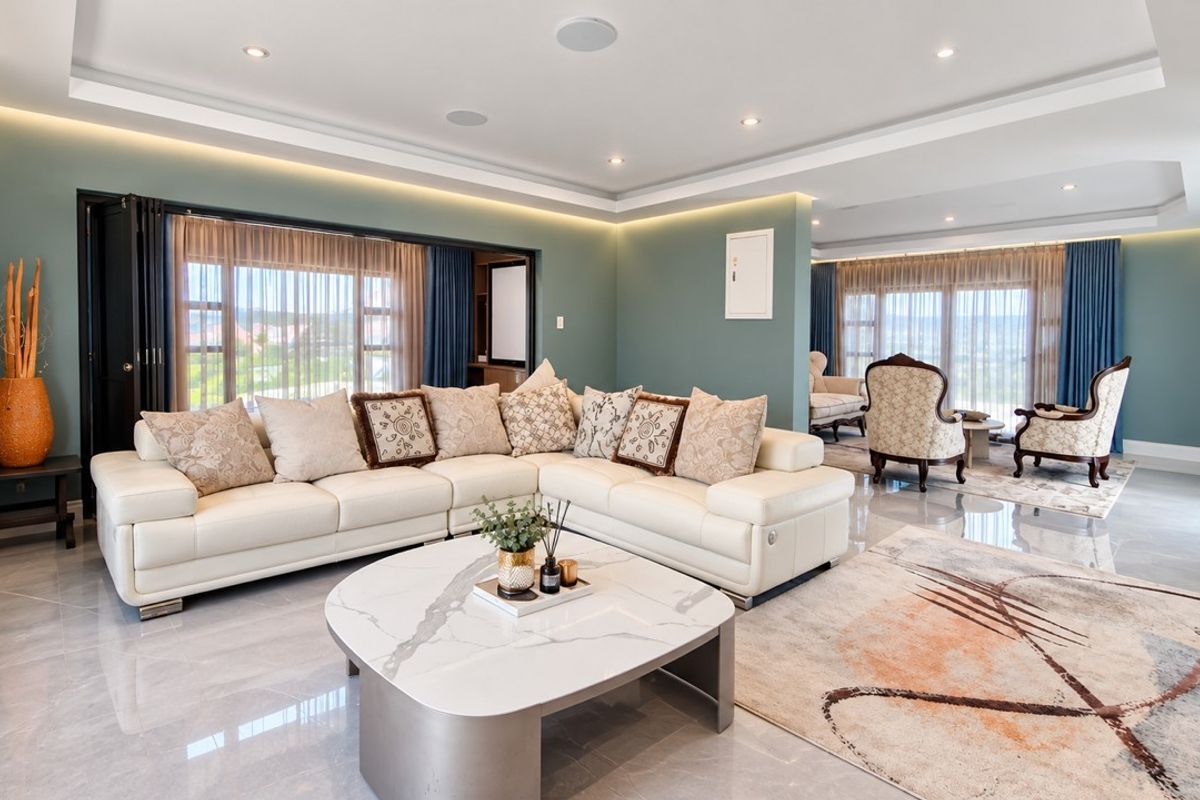 Spacious, modern living area featuring polished tile floors, recessed cove lighting, and large sliding glass doors that provide ample natural light.