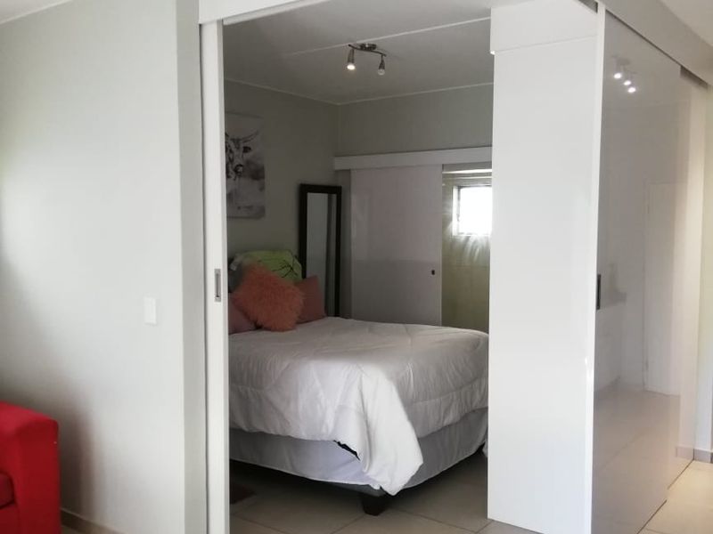 A bedroom featuring modern tiled flooring and a functional sliding door partition, providing a flexible layout within the apartment space.