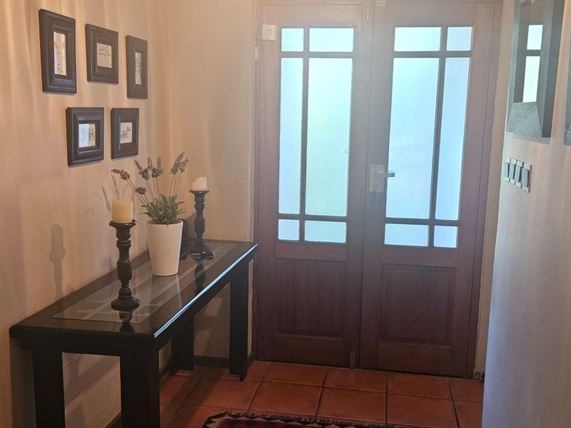 Welcoming entrance hall featuring double timber doors with frosted glass panels and durable terracotta floor tiles.