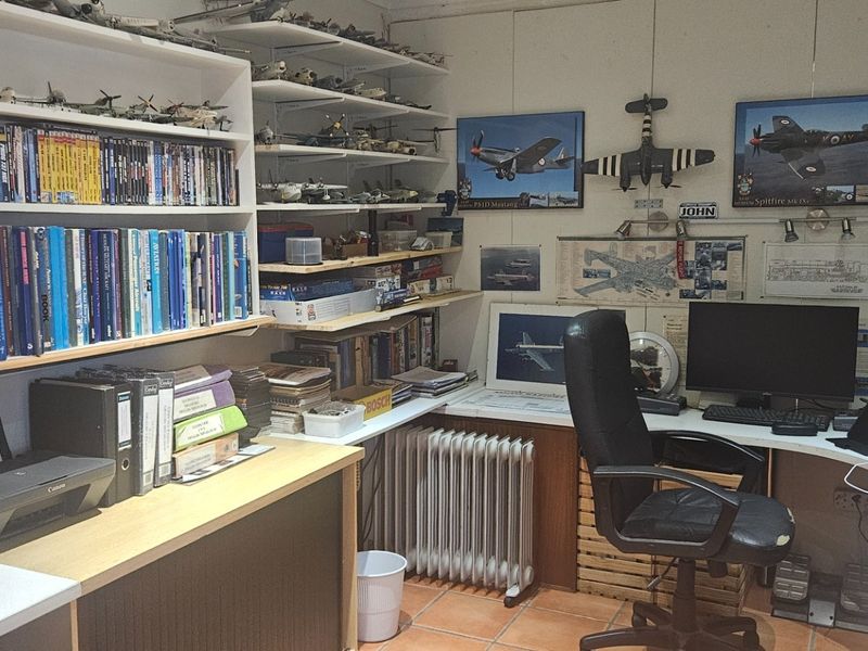 A functional home office space featuring extensive built-in shelving and a fitted desk area, suitable for a dedicated workspace or study.