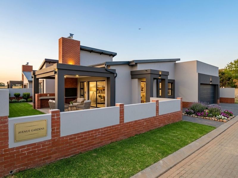 Modern single-story residence featuring a brick and rendered facade, covered patio with built-in fireplace, landscaped garden, and an integrated garage.