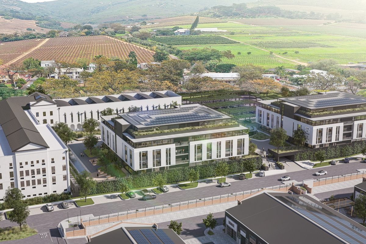 Aerial view of a modern office park complex featuring contemporary architecture, solar panels, green roofs, and landscaped outdoor spaces in a scenic setting.