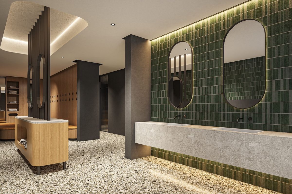 Modern, high-end office bathroom featuring a double vanity with integrated sinks, stylish green tiled feature wall, and premium terrazzo flooring.