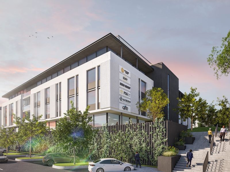 A modern multi-story office building featuring contemporary architectural design, large glass windows, and integrated landscaped parking areas.