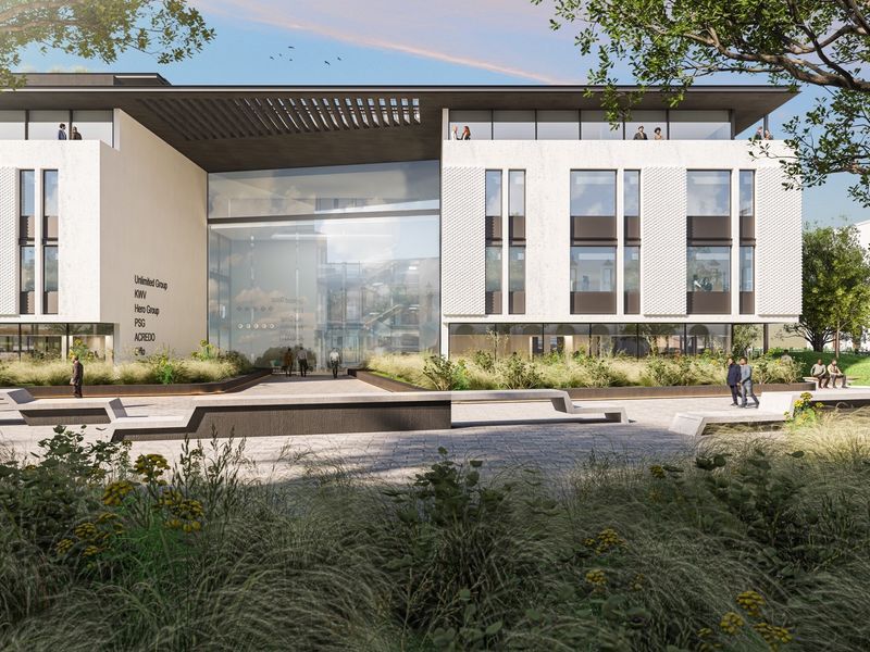 Modern office building exterior featuring a prominent glass atrium entrance, textured facade, and a landscaped public plaza with paved walkways.