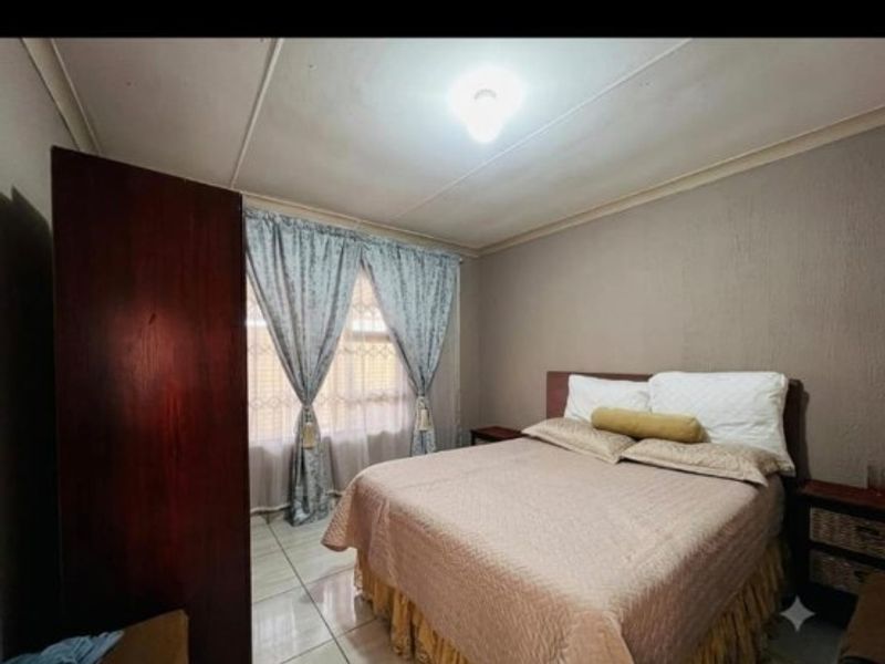 A standard bedroom featuring tiled flooring, a built-in wardrobe, and coved ceiling details.