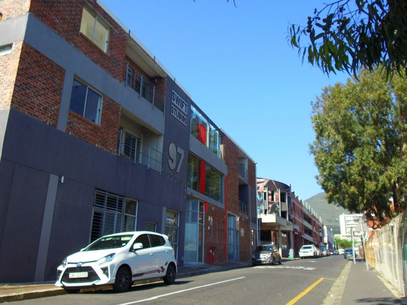 Street-level view of the Swift Studios apartment building, featuring a modern brick and rendered facade with balconies and large windows.