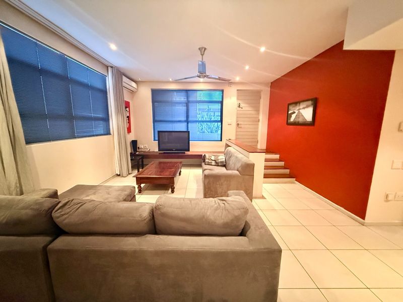 Spacious living room featuring tiled flooring, recessed lighting, a ceiling fan, air conditioning, and a staircase leading to an upper level.