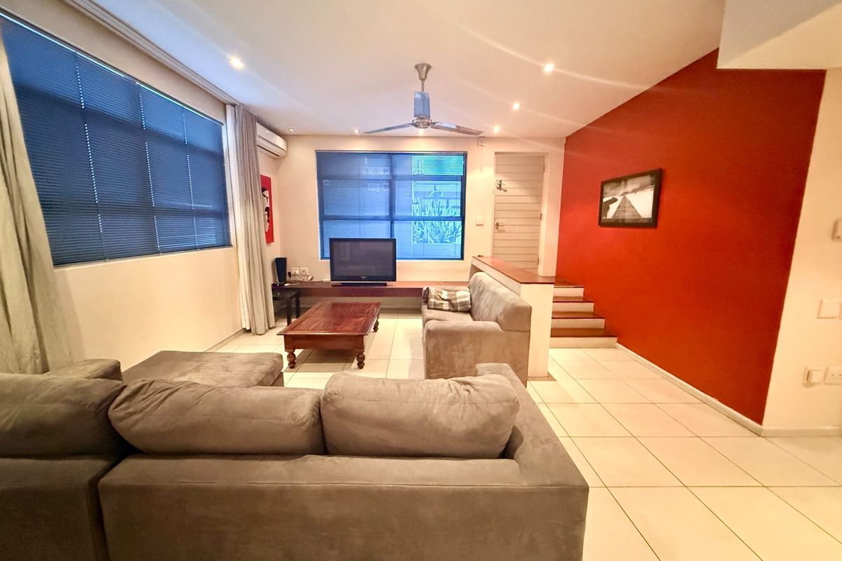 Spacious living room featuring tiled flooring, recessed lighting, a ceiling fan, air conditioning, and a staircase leading to an upper level.