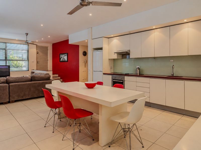 Spacious open-plan living and dining area featuring a modern kitchen with built-in cabinetry, integrated appliances, and tiled flooring throughout.