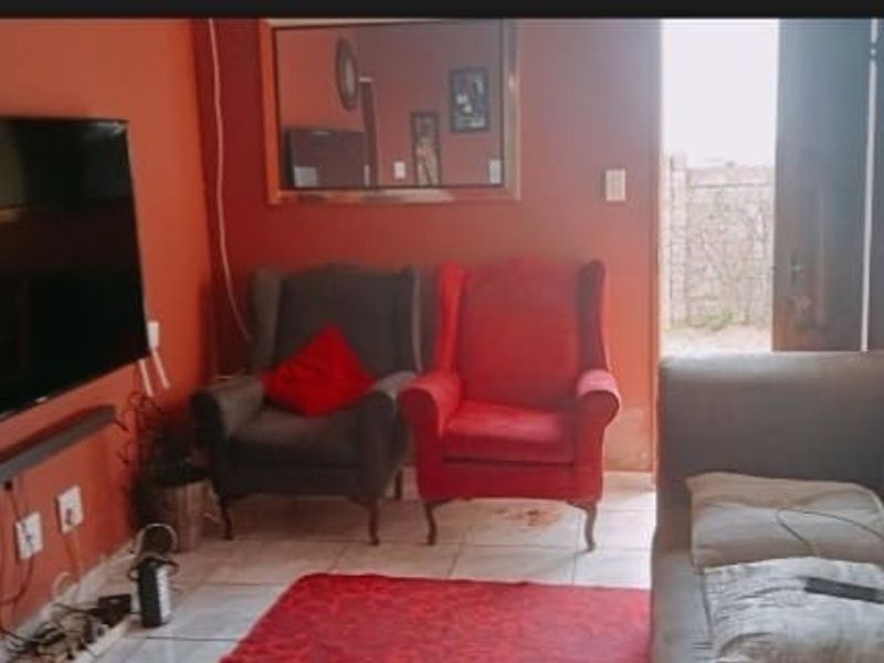 A living room area featuring tiled flooring and direct access to an outdoor space.