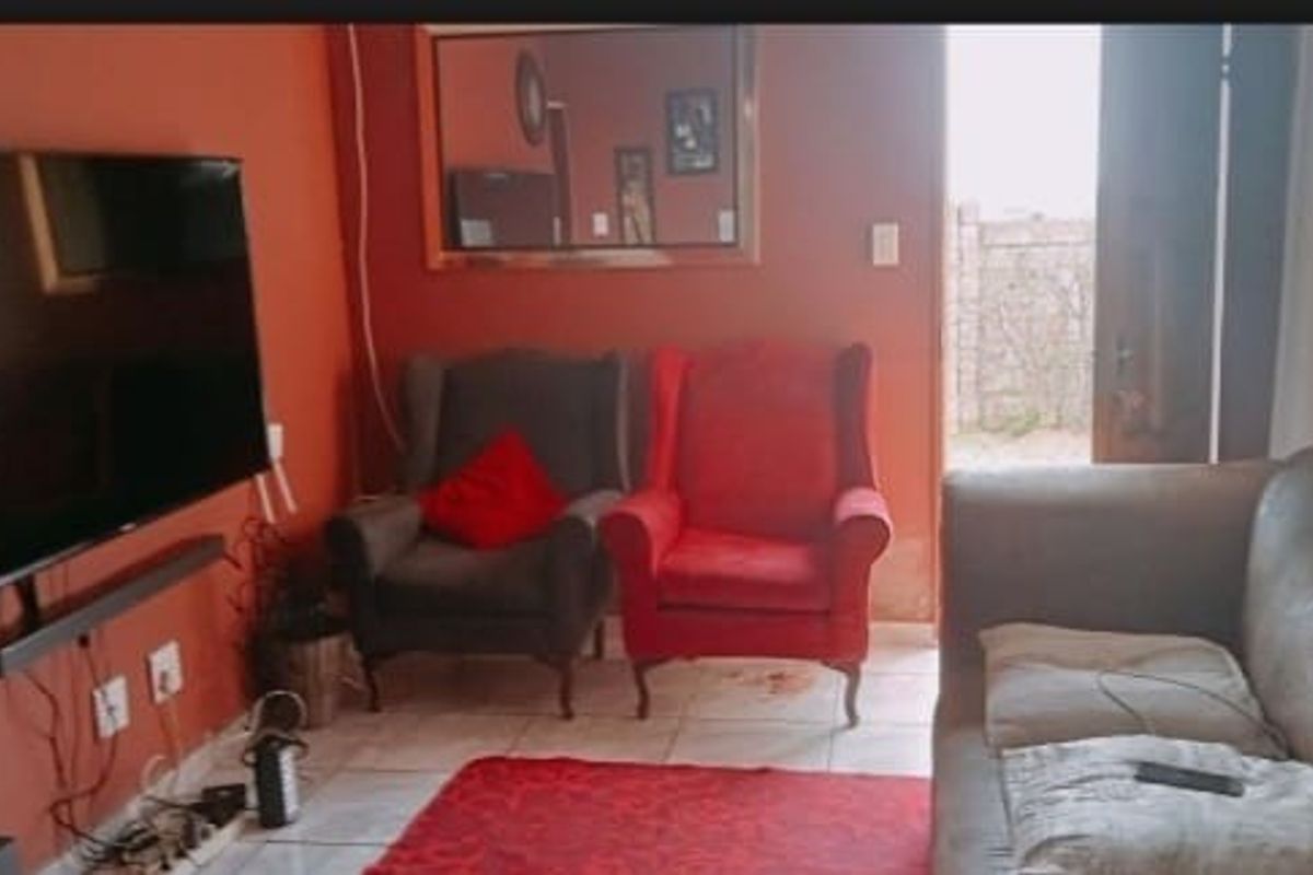 A living room area featuring tiled flooring and direct access to an outdoor space.