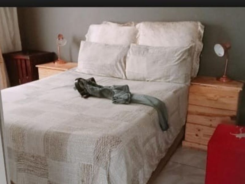 A bedroom featuring tiled flooring and neutral wall tones, providing a functional space for rest.