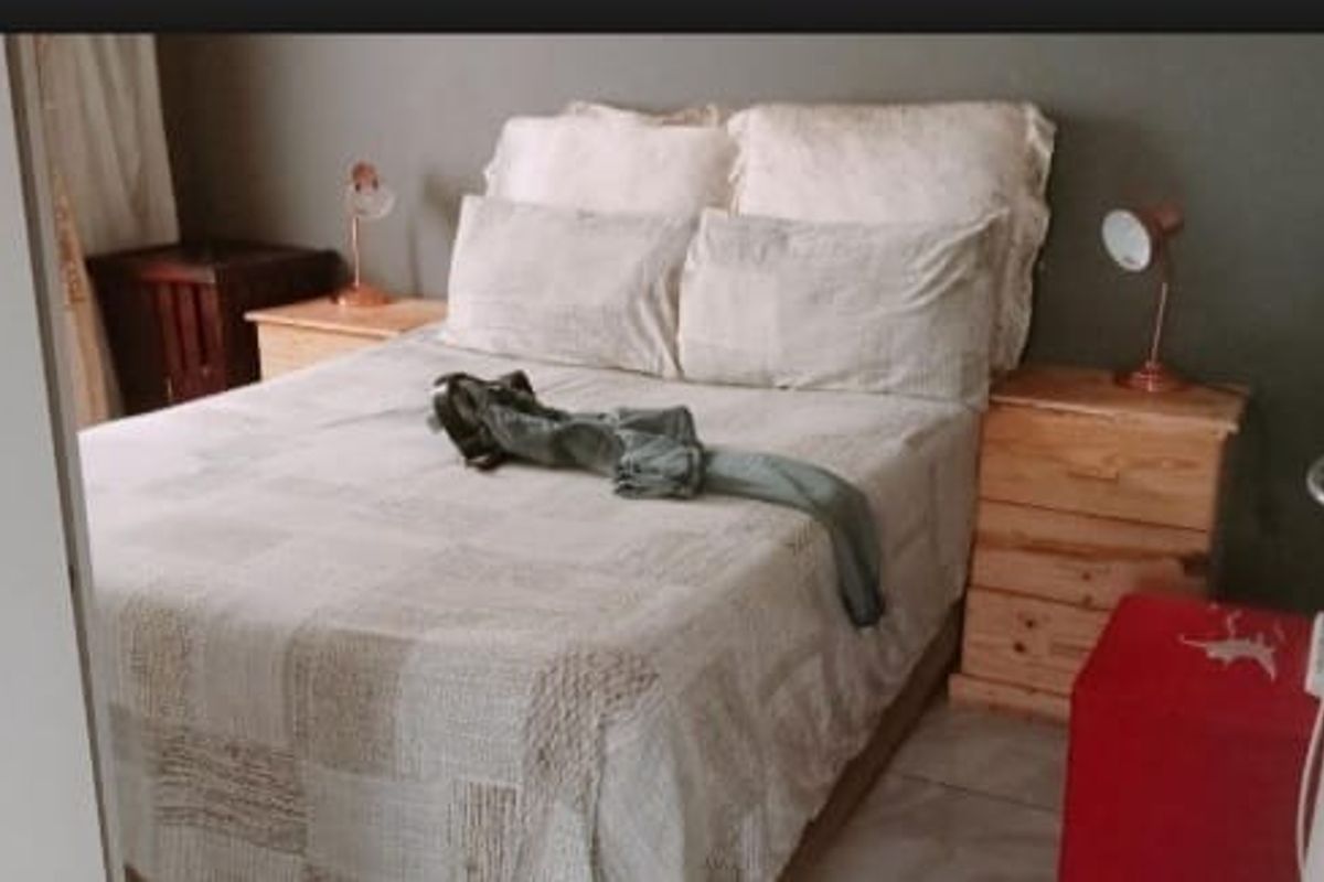 A bedroom featuring tiled flooring and neutral wall tones, providing a functional space for rest.
