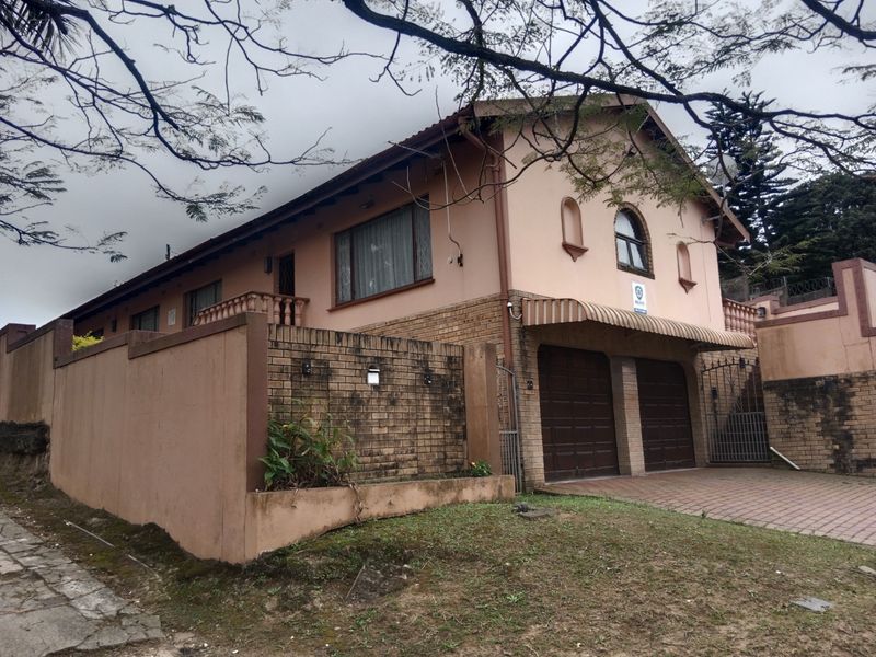 Front elevation of a double-story house featuring a double garage, paved driveway, and perimeter brick walling.