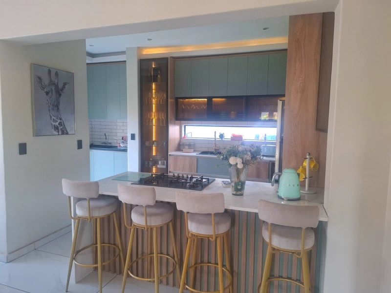 Modern kitchen featuring sleek cabinetry, stone countertops, a built-in gas hob, and integrated lighting, creating a functional and stylish culinary space.