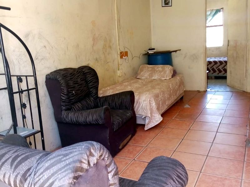 A living area featuring ceramic floor tiles, requiring significant wall and ceiling repairs to improve the overall condition of the space.